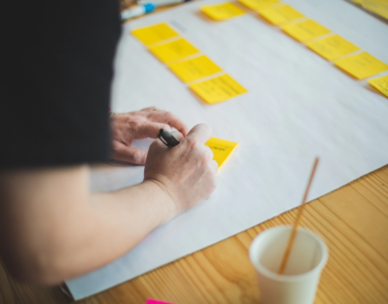 Person skriver på post-it lappar.webp